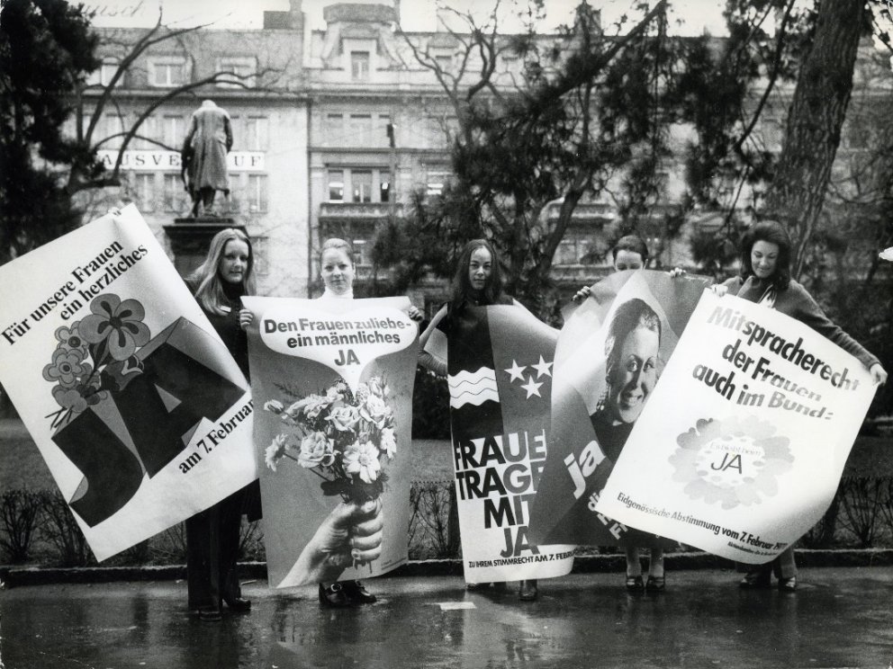 Frauen mit kantonalen und eidgenössischen Frauenstimmrechtsplakaten. Quelle unbekannt