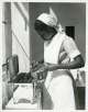 Anonyme, Janet Ndoti pendant sa formation à l'hôpital King George V de Nairobi. L'une de ses tâches consiste à stériliser les instruments dans le bloc opératoire, Kenya, 1952. Musée international de la Croix- Rouge et du Croissant-Rouge, Genève.
